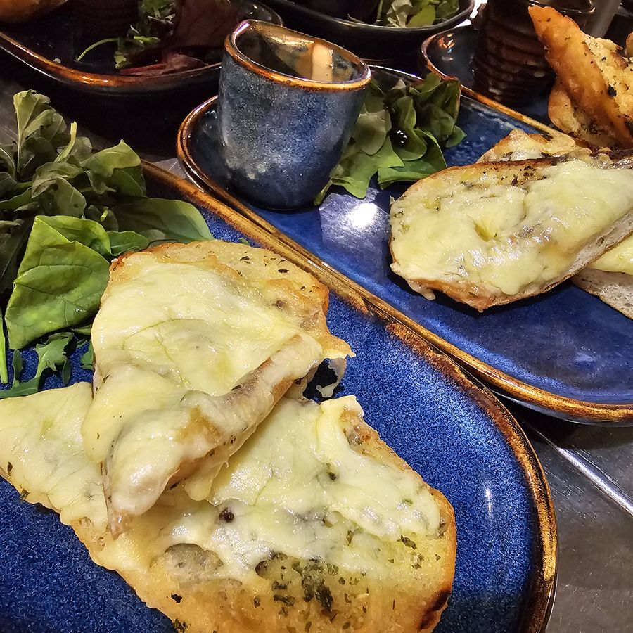 Cheesy garlic bread with dressed leaves